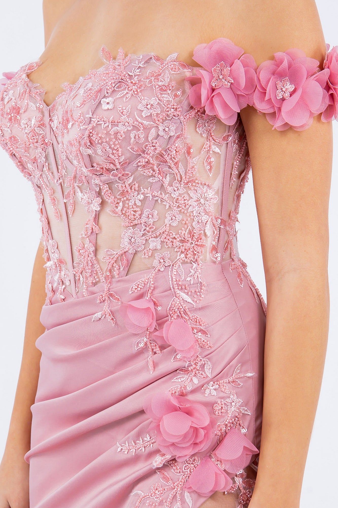 A close-up of a person wearing the Off-the-Shoulder Floral Embroidered Prom Dress 8050J in pink, showcasing floral appliqué, lace details, and sheer panels.
